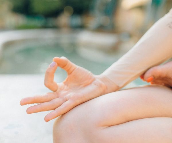 Person meditating peacefully in a serene natural setting.